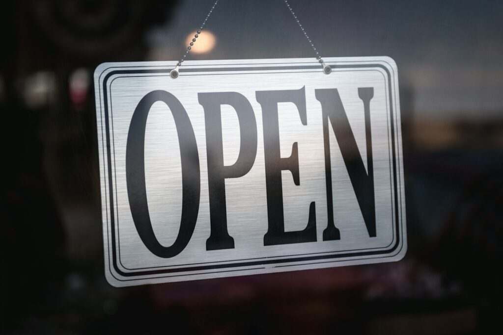 Open sign hanging on a small local business front door