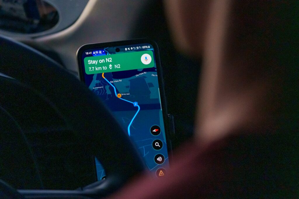 Person using a navigation app on a smartphone while driving