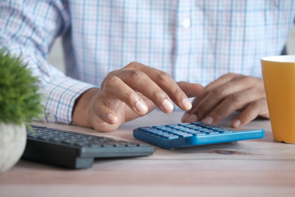 Small business owner using a calculator to work out whether SEO is worth the investment