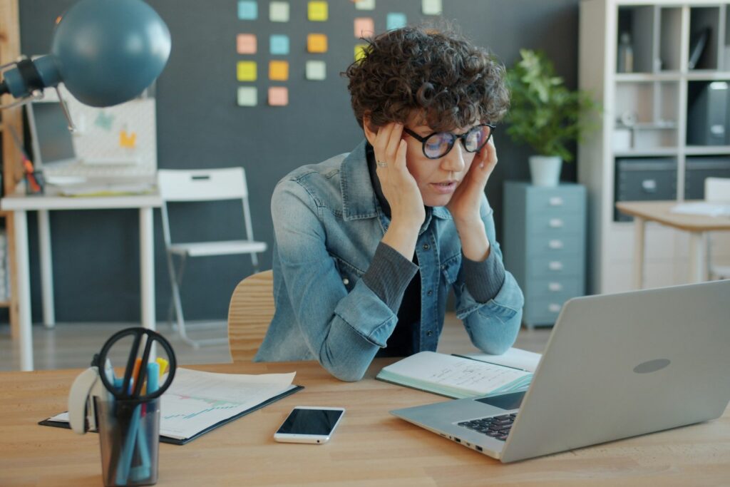 Business owner reviewing customer feedback thoughtfully on a laptop in a calm office setting