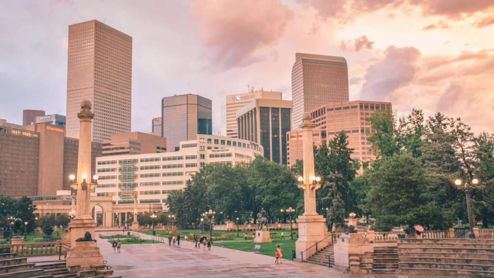 Denver Civic Center Park with downtown buildings at dusk