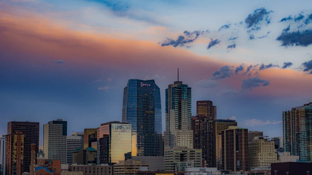 Downtown Denver skyline at sunset with pink and orange clouds