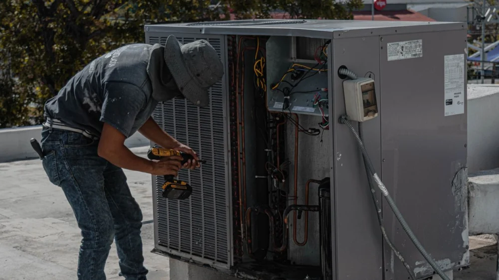 Technician servicing a rooftop HVAC unit